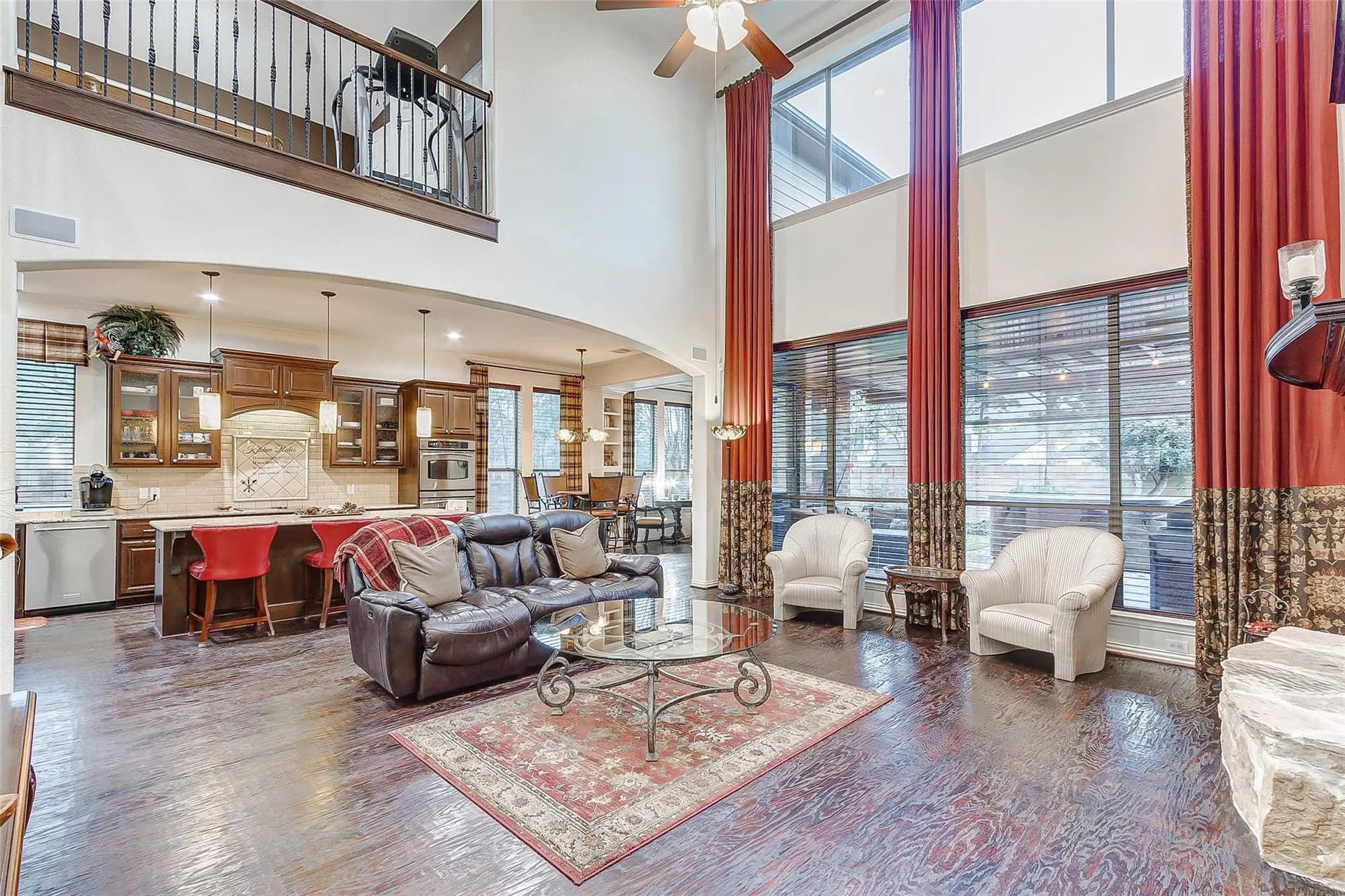 Two story family room with a loft above, open to the kitchen, in a home in Eagle Springs, Humble, Texas